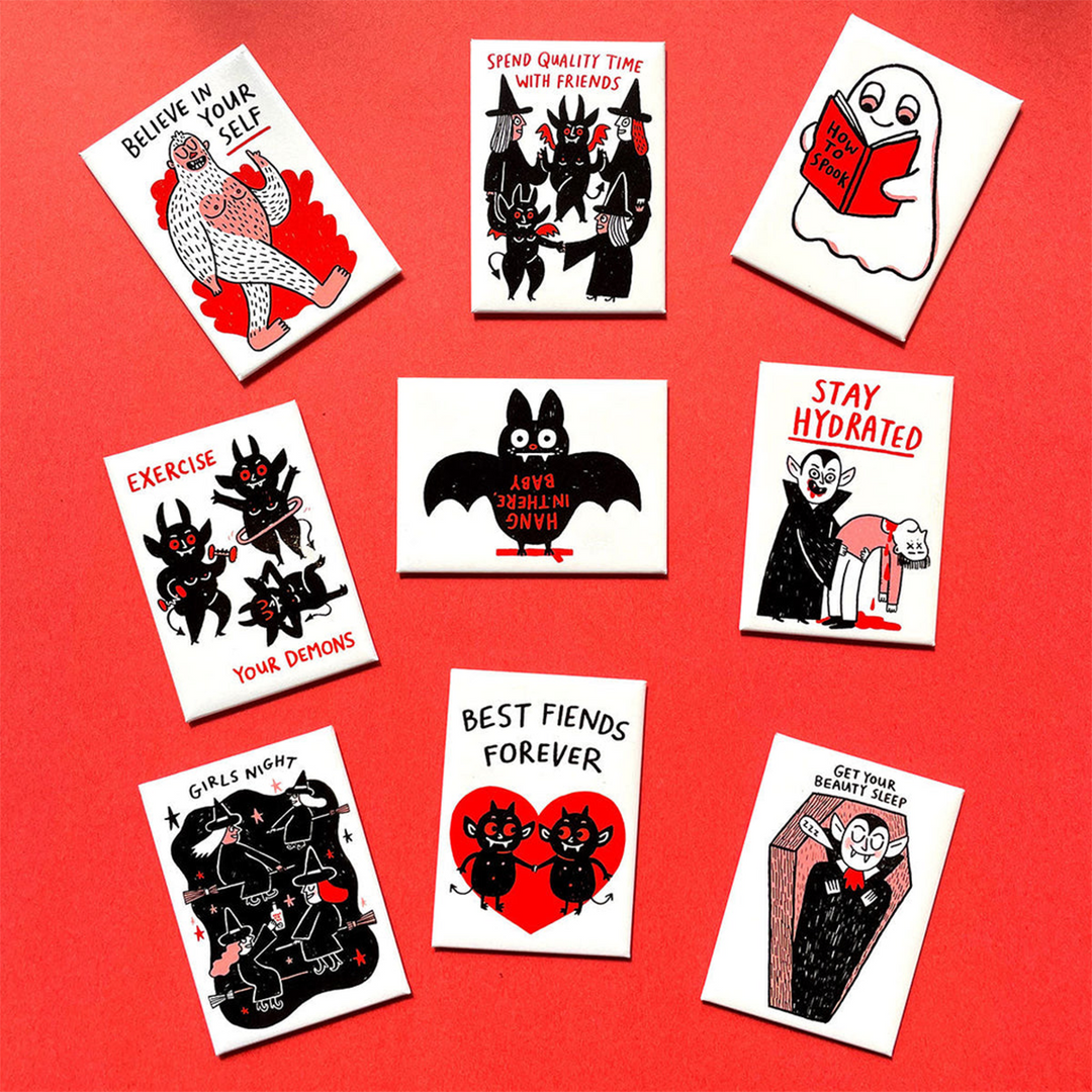 A set of nine white rectangular fridge magnets with black and red cartoon illustrations and humorous halloween-themed quotes, arranged on a solid red background.