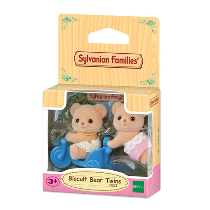 Calico Critters Biscuit Bear Twins toy set in its original wooden-look retail packaging, featuring two small teddy bear figures in pink and yellow outfits riding and pushing a blue bicycle cart.