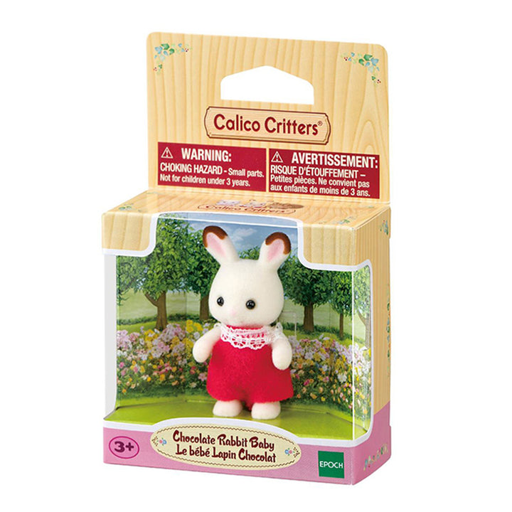 Calico Critters Chocolate Rabbit Baby toy in its original wooden-look retail packaging, featuring a white rabbit figure with brown-tipped ears in a red outfit with white lace frill collar.