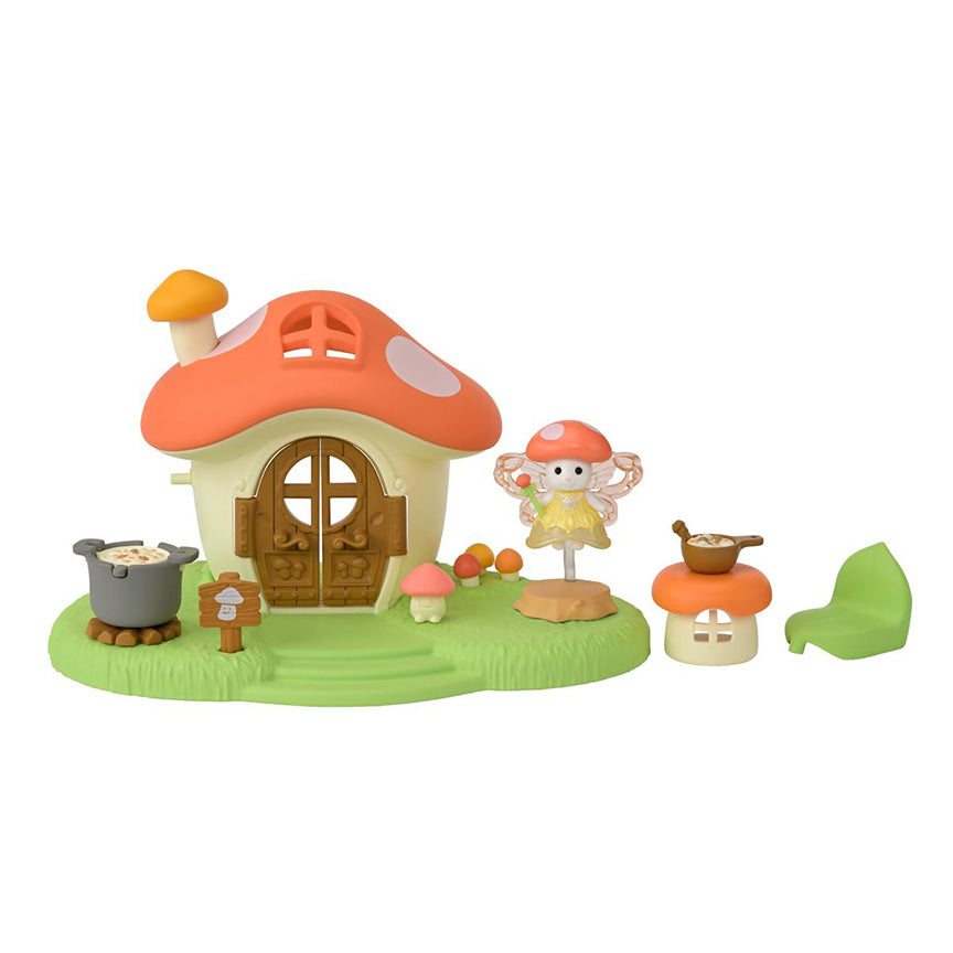 Plastic red and white mushroom toy house with wooden doors on a plastic grass set up. Featuring a wooden sign with a smiling mushroom on it, three mushrooms growing out of the grass, a small smiling mushroom toy, and a movable pot on soup on firewood. Set also features a small mouse-like sniaml with fairy wings and a yellow dress and wand, wearing a mushroom cap hat. Mushroom table, bowl of soup, and leaf chair also included.