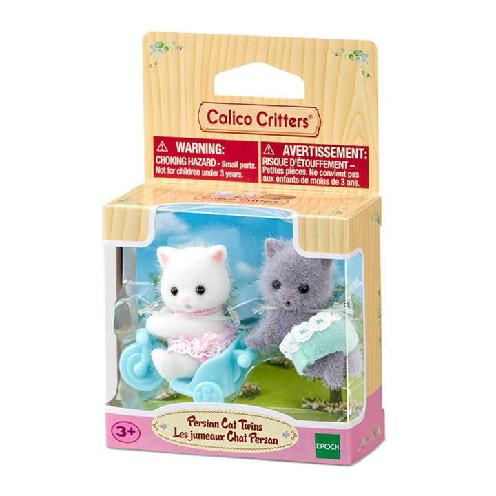 Calico Critters Persian Cat Twins toy set in its original wooden-look packaging, featuring two small cat figures in pink and green outfits riding and pushing a blue bicycle cart.