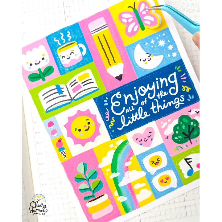 Colorful sticker sheet with various illustrations and text, held by a hand.
