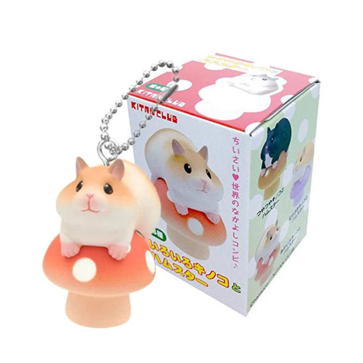 Hamster figurine keychain on a mushroom stand with packaging in the background.
