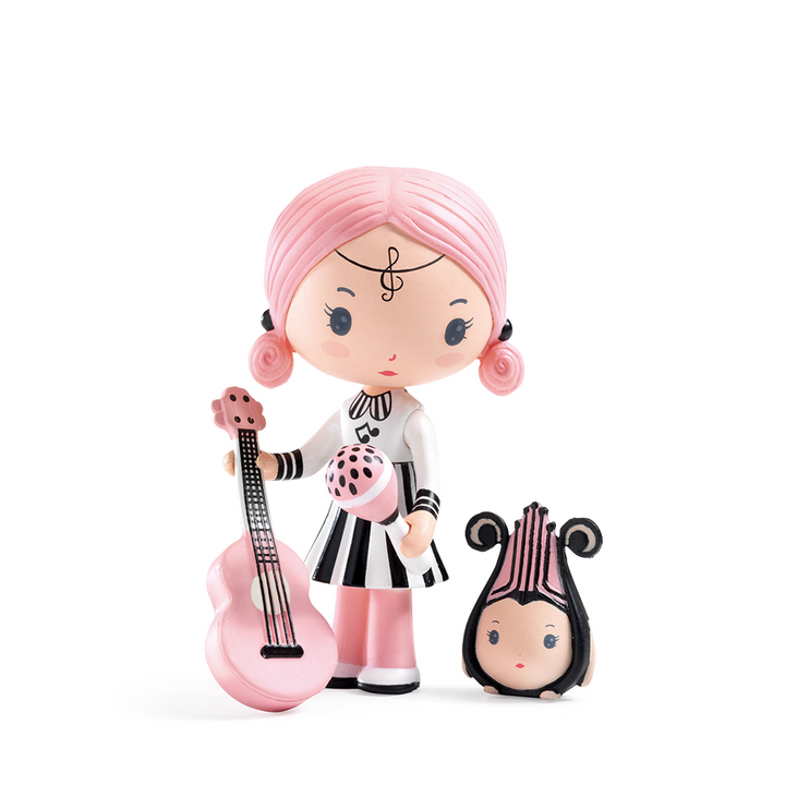 A toy figurine of a music-themed girl with pale skin and pink hair holding a pink guitar and polkadot maraca. She wears a black and white striped dress with music notes and a treble clef headband. She stands next to a smaller matching figurine stylized like a harp with a cute face. Figurines are displayed on a white background. 