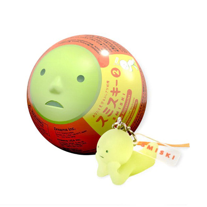 Green Smiski ball with packaging and a keychain on a white background.