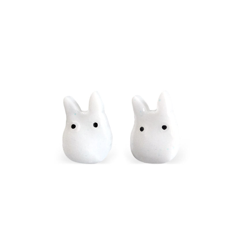 A pair of white chibi-style Totoro stud earrings with black eyes.