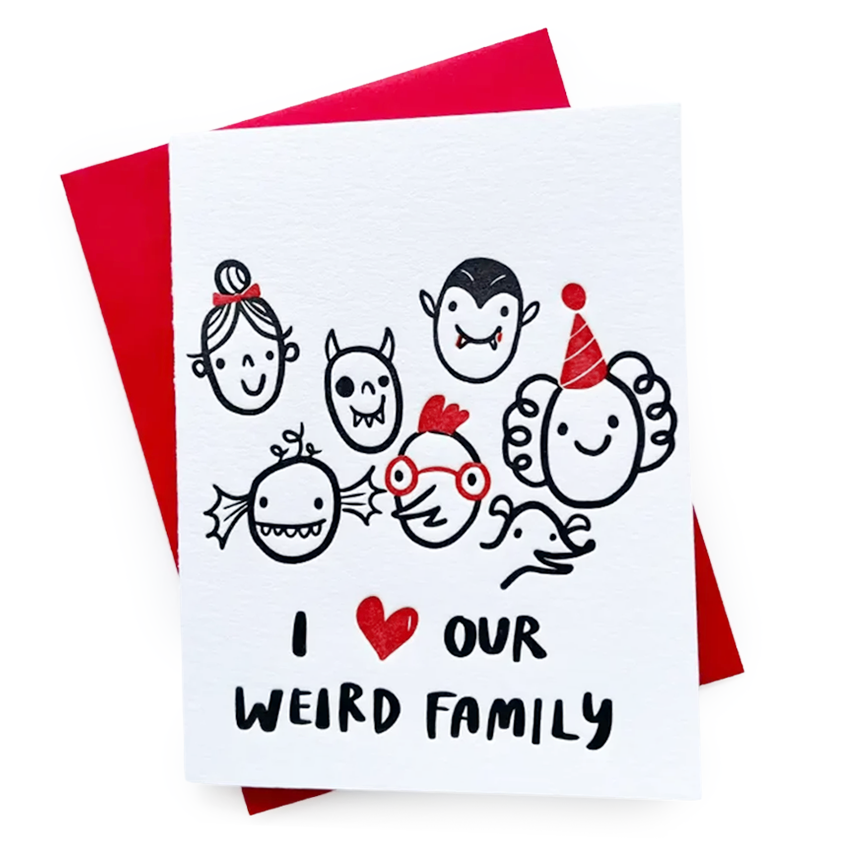 A white greeting card with a red envelope behind it, featuring an embossed black and red illustration of a family composed of vampires, ghouls, and other goofy characters over the text 'I HEART OUR WEIRD FAMILY'.