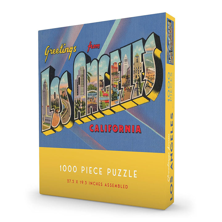 A blue and yellow puzzle box depicting the puzzle which says "Greeting from Los Angeles California" in a vintage design with depiction of LA buildings and environments inside the letters. Letters are set on a blue background. 