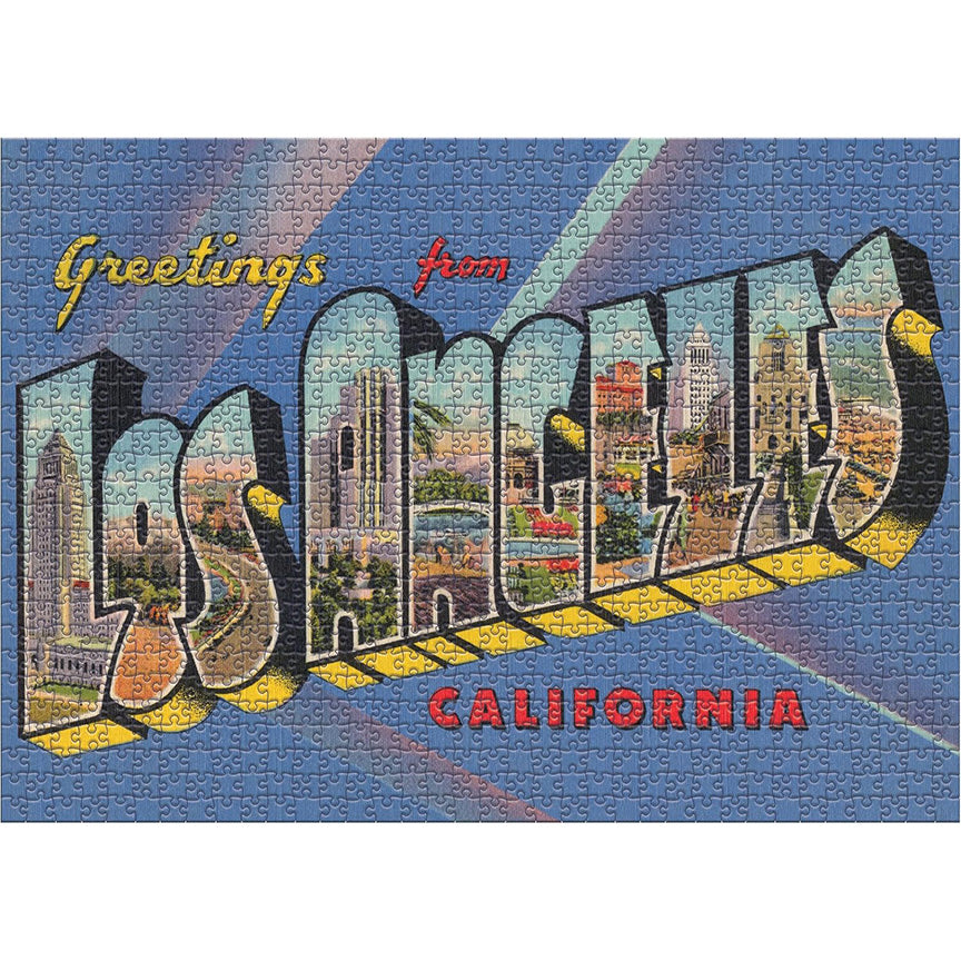 A completed landscape-style jigsaw puzzle featuring the words 'Greetings from Los Angeles California' in large 3D letters, with cityscape scenes filled inside each letter on a blue background.