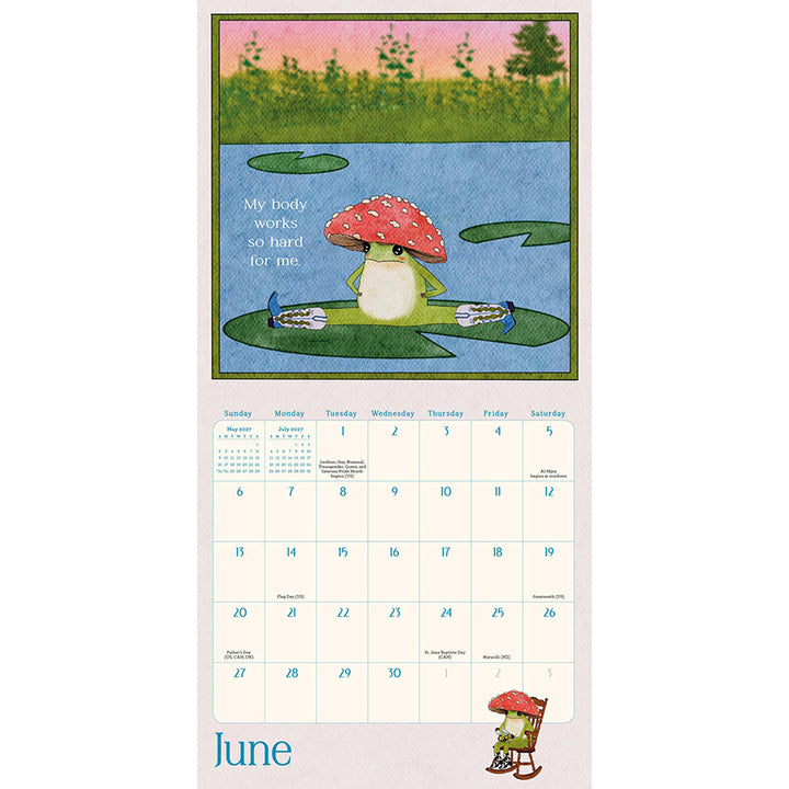 A printed June calendar page featuring a whimsical frog with a red mushroom hat and cowboy boots doing the splits on a lily pad, with a small monthly calendar grid below.