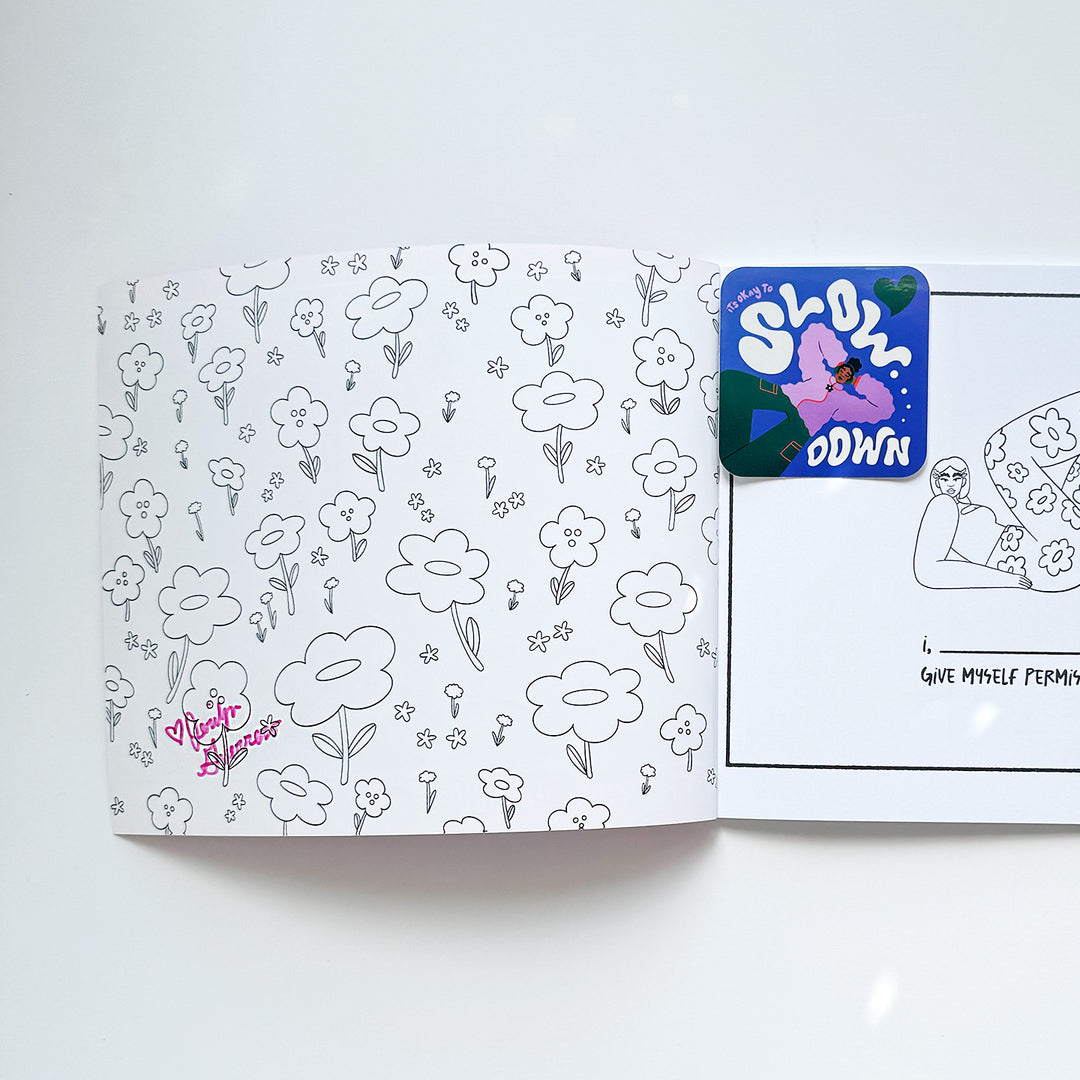 Cover page of coloring book with black  and white line drawings of flowers. Sitting inside the cover is a sticker with art that features a black girl with a purple jacket relaxing, and text that says "Slow Down". The inside cover is also signed in pink marker by the artist. 