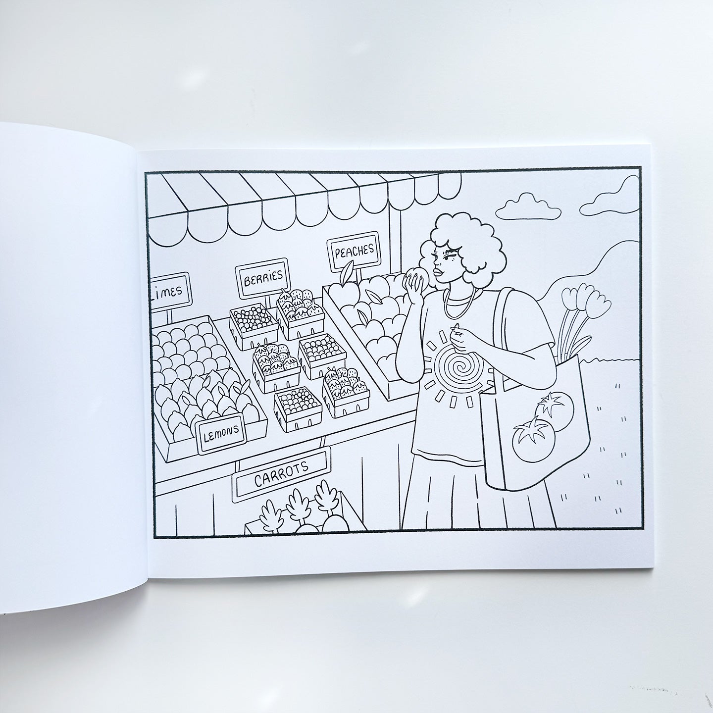 Black  and white line drawing coloring page featuring an image of a girl with curly hair and a tomato tote bag picking out fruit at an outdoor market. 