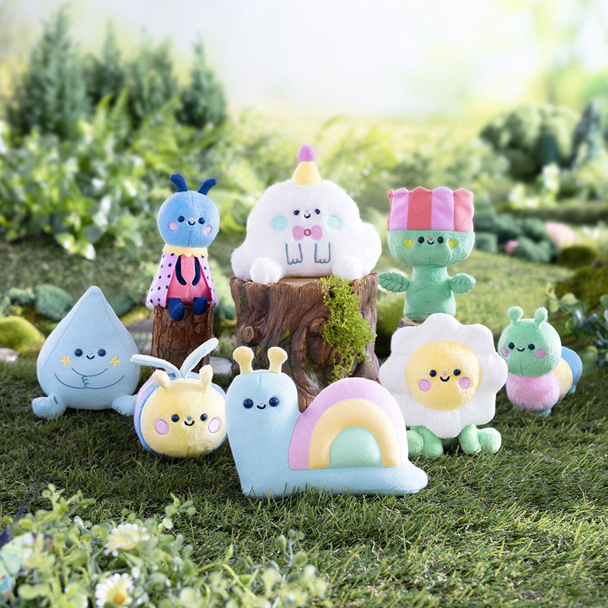 Picture of nine varying plush designs possible in blind box, including a secret design only half shown. All characters are nature themed with designs like clouds, plants, cute bugs, and more. Characters are on a meadow-like background. 