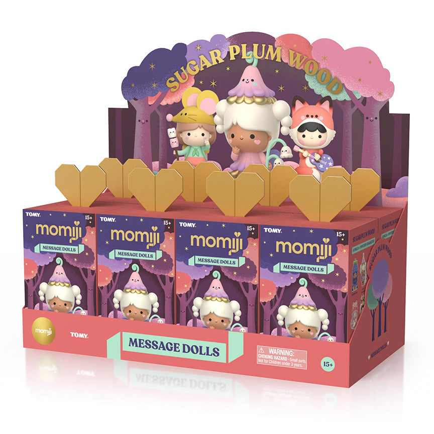 A Sugar Plum Wood Momiji Message Dolls display box filled with eight individual blind box packs with cartoon characters and gold heart-shaped flaps. 