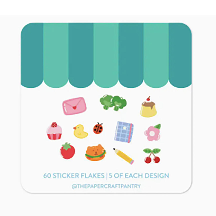 The back of the packaging with a teal-and-white storefront awning design and small illustrated sticker-flake icons below, including a pink envelope, green broccoli, yellow duck, red strawberry, orange burger, blue notebook, pink flower, cherries, and other small motifs. 