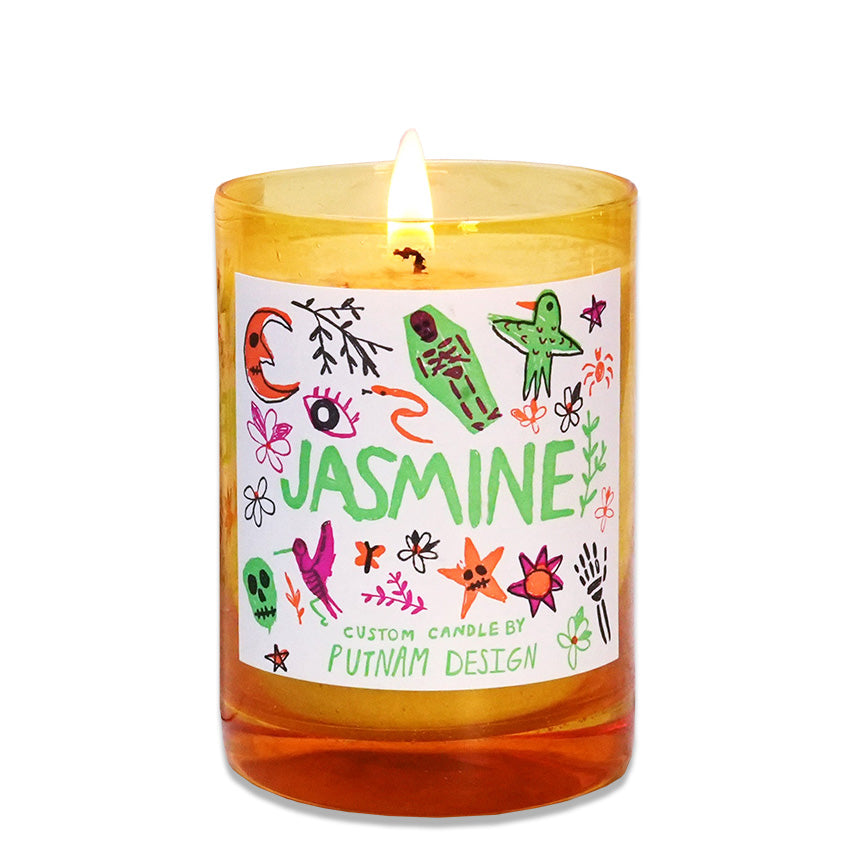 Yellow glass candle with illustrated decorative label and the text "Jasmine custom candle by Putnam Design" on a white background. 