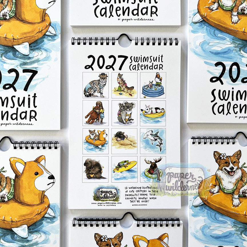 The back of a spiral-bound 2027 animal swimsuit calendar featuring multiple animal in swimsuit images for each month. Animals include a frog, shark, porcupine, and more. 
