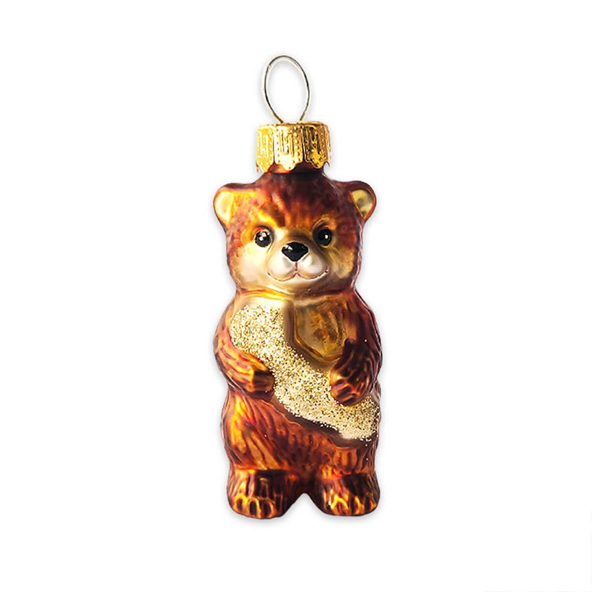 A molded-glass ornament in the shape of a small brown bear hugging the a glittery gold version of the state of California.