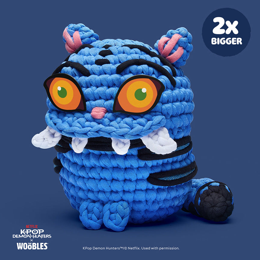 Finished crochet—  derpy tiger from Kpop Demon Hunters, blue tiger with big yellow eyes and white teeth. 