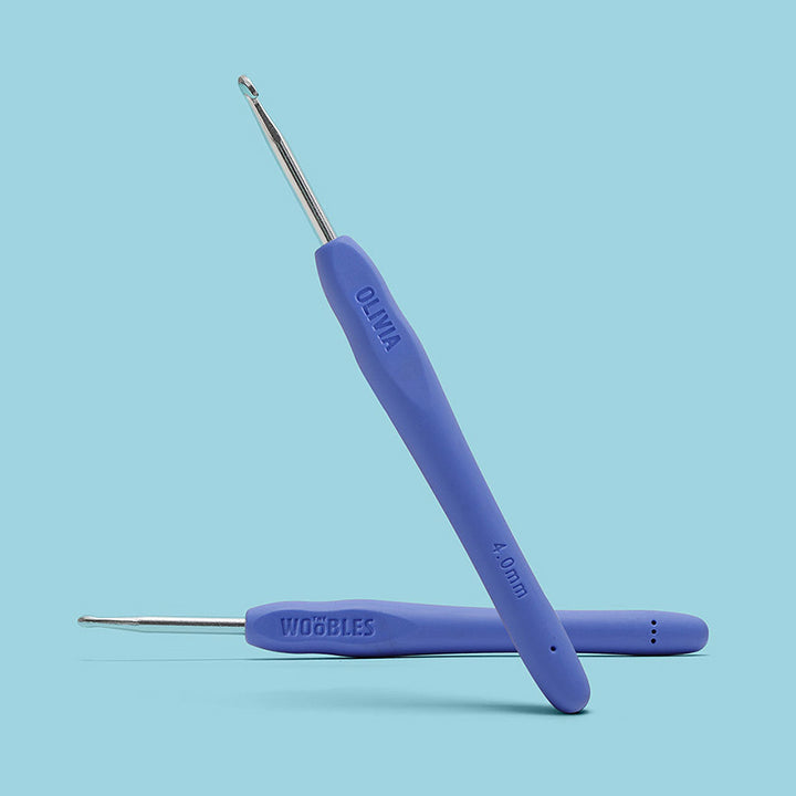 Two blue crochet hooks with metal ends on a light blue background