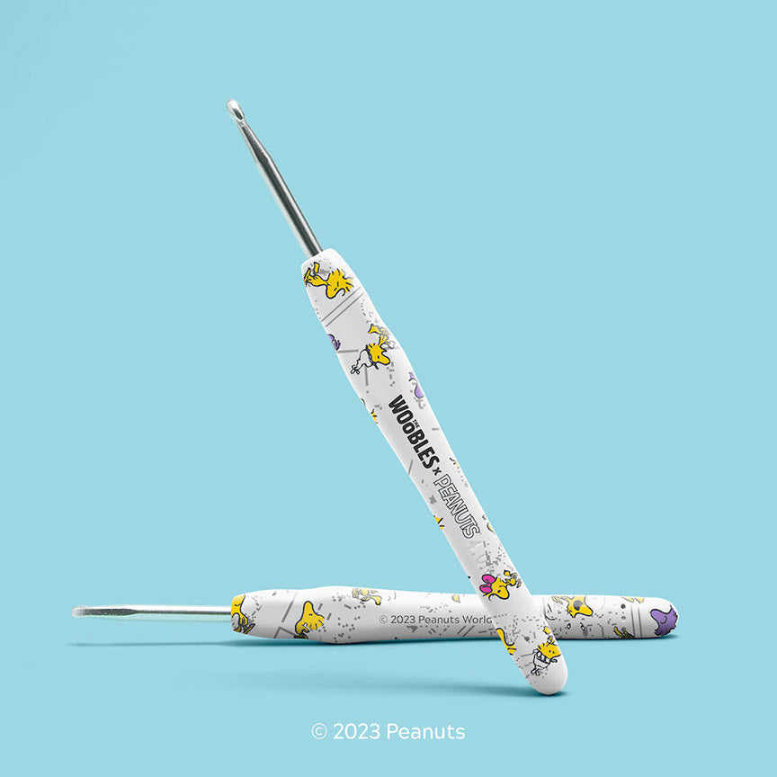Crochet hooks with Peanuts character design on a light blue background.