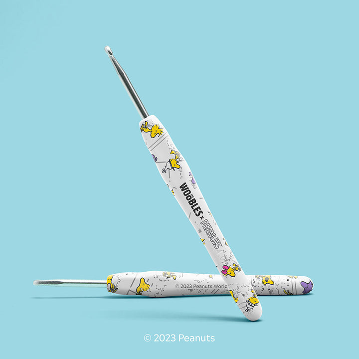 Crochet hooks with Peanuts character design on a light blue background.