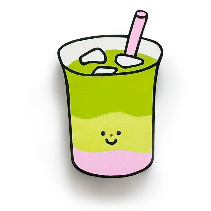 An art piece of a matcha drink with three layers: bright green on top, light yellow-green in the middle, and pink on the bottom, with a small smiling face and a pink straw.