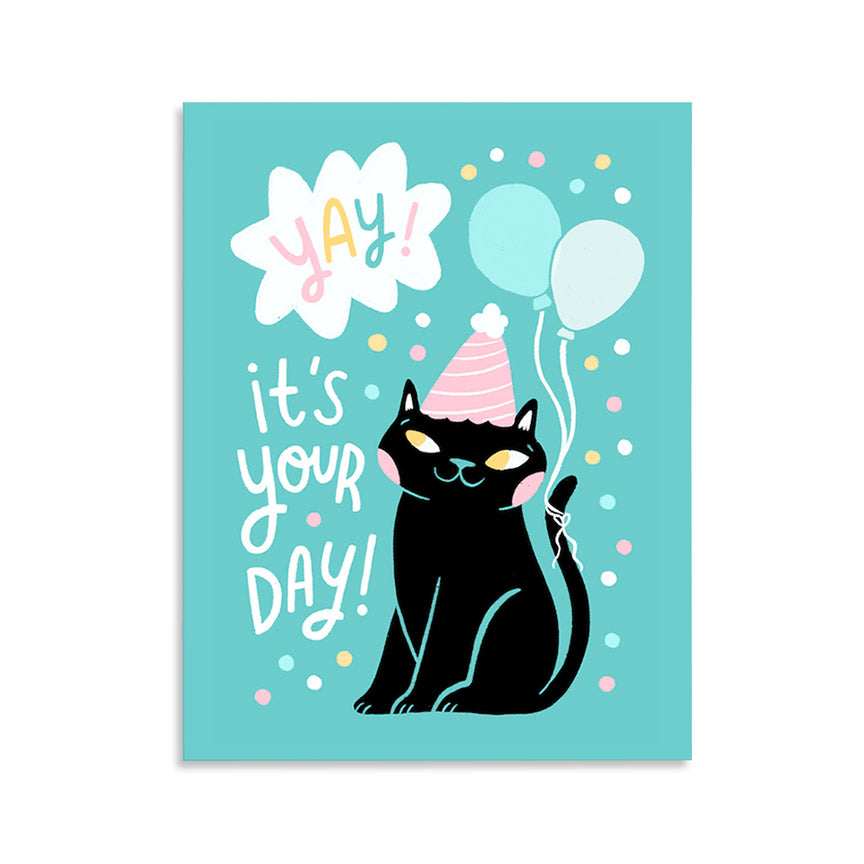 A colorful card with an illustration of a black cat wearing a party hat and balloons, with the text &