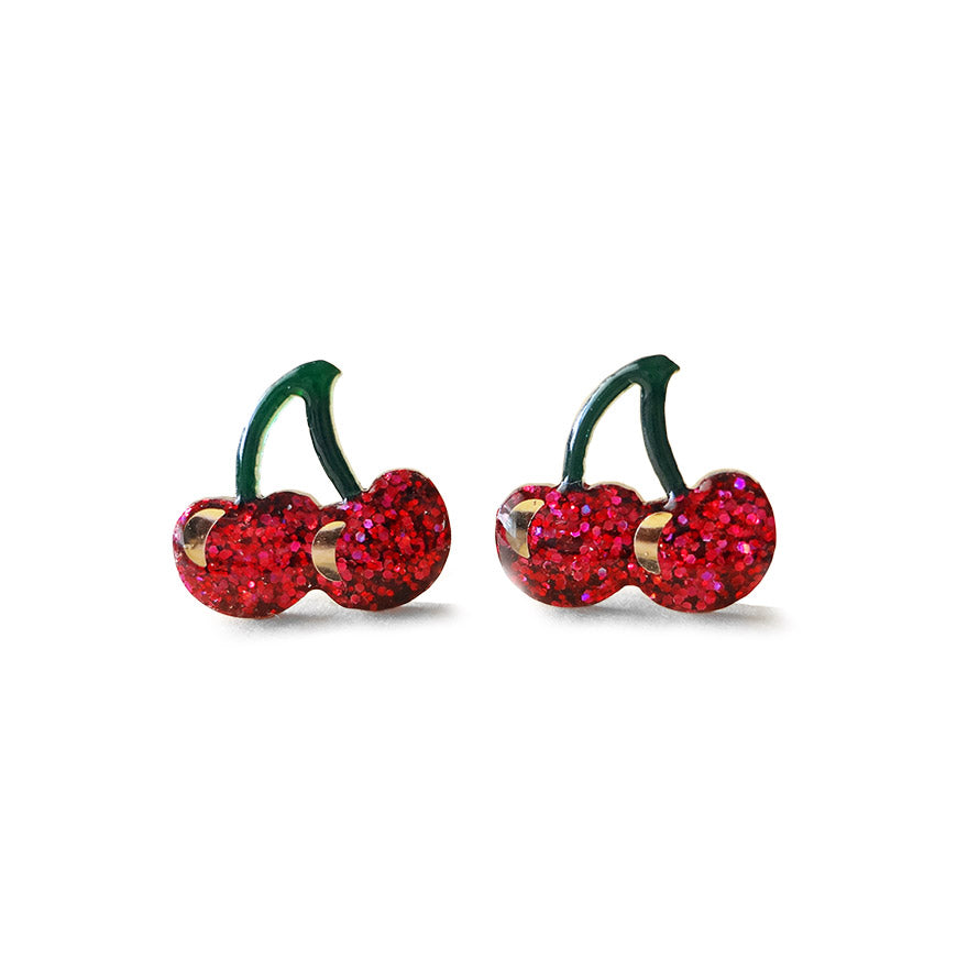 A pair of glittery cherry-shaped stud earrings with red fruit and green stems.